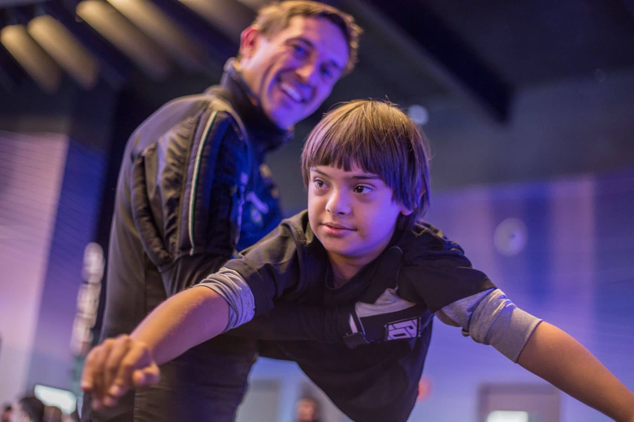 Child in flying position being held by instructor