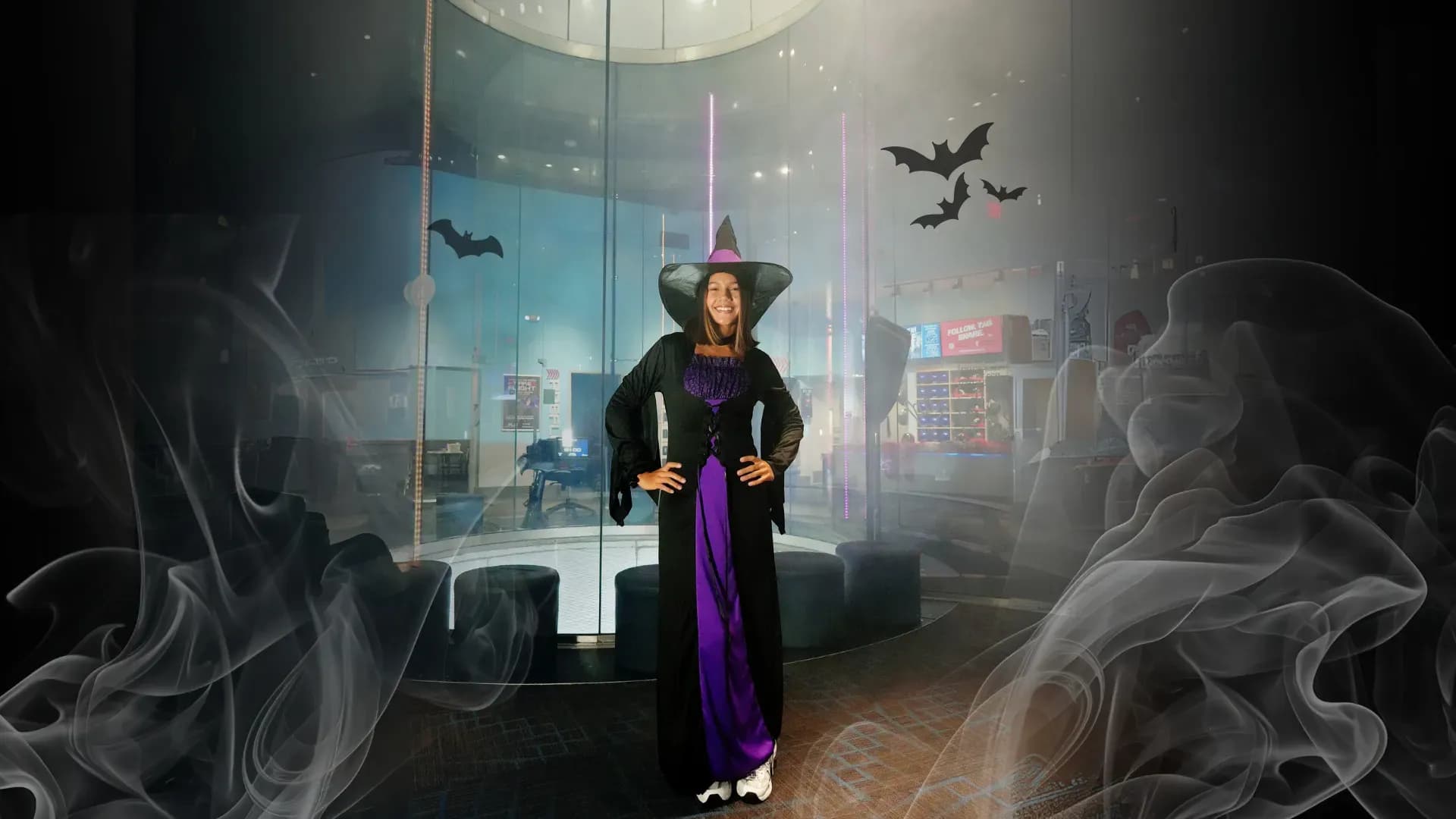 Woman in witch costume standing in front of the wind tunnel