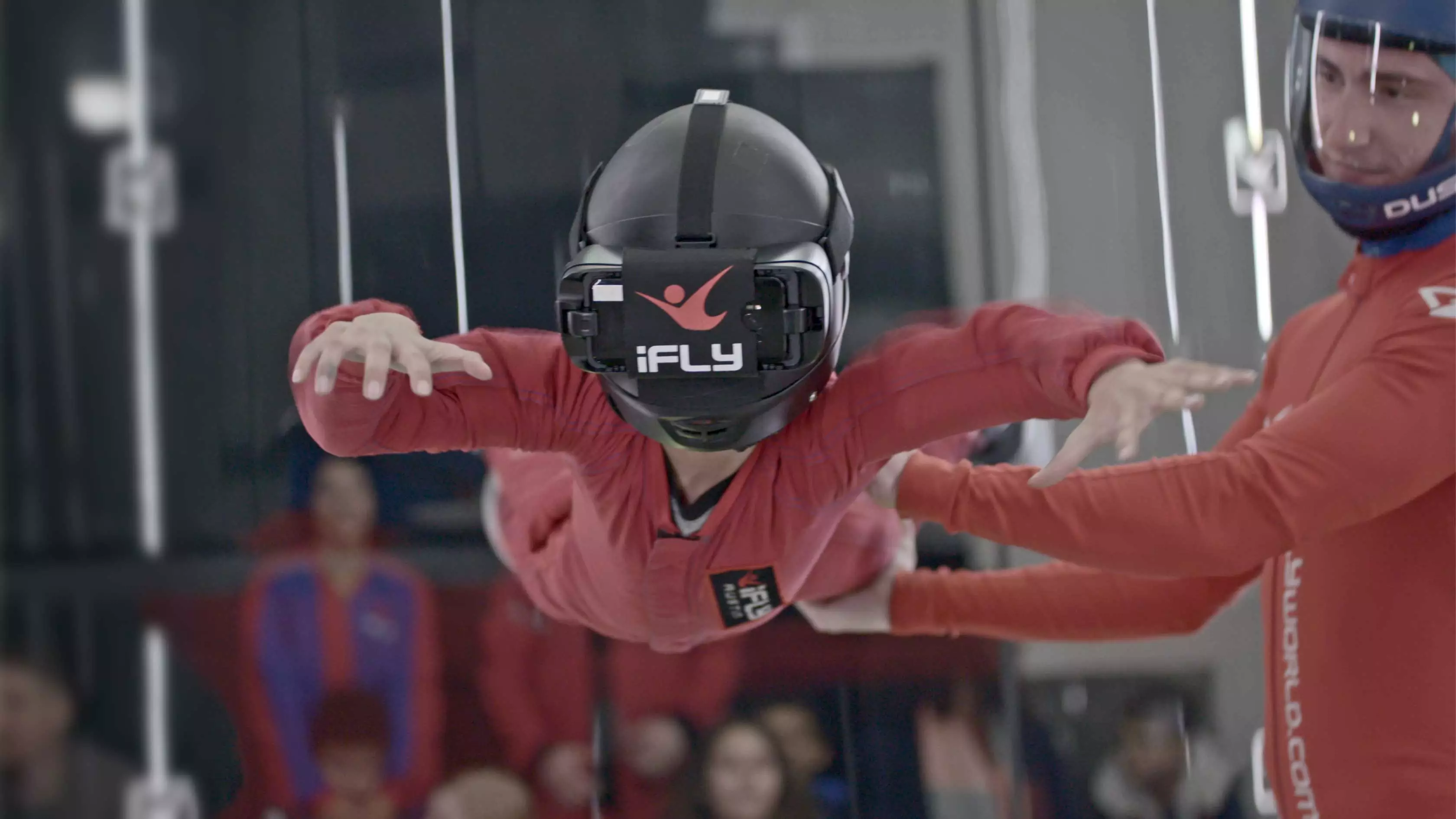 Young child flying in an iFLY tunnel with VR goggles on