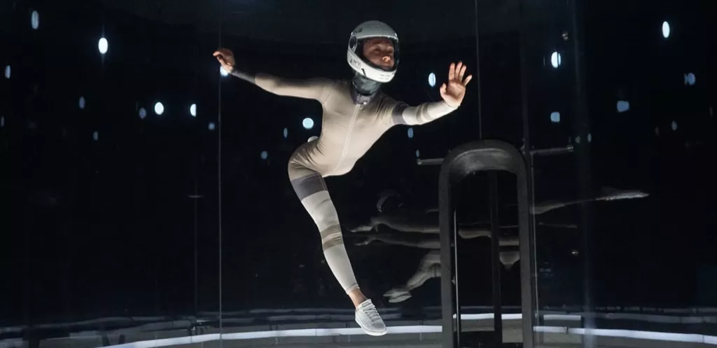 Girl flying in an indoor skydiving tunnel while posing