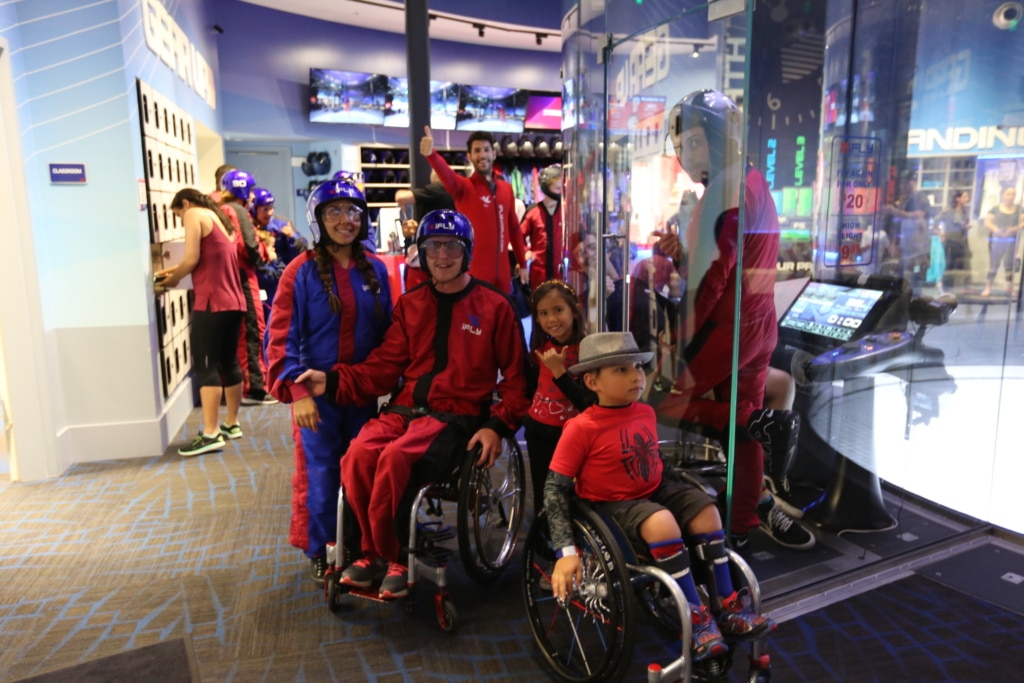 Smiling disabled adults and children posing and getting ready to fly at iFLY